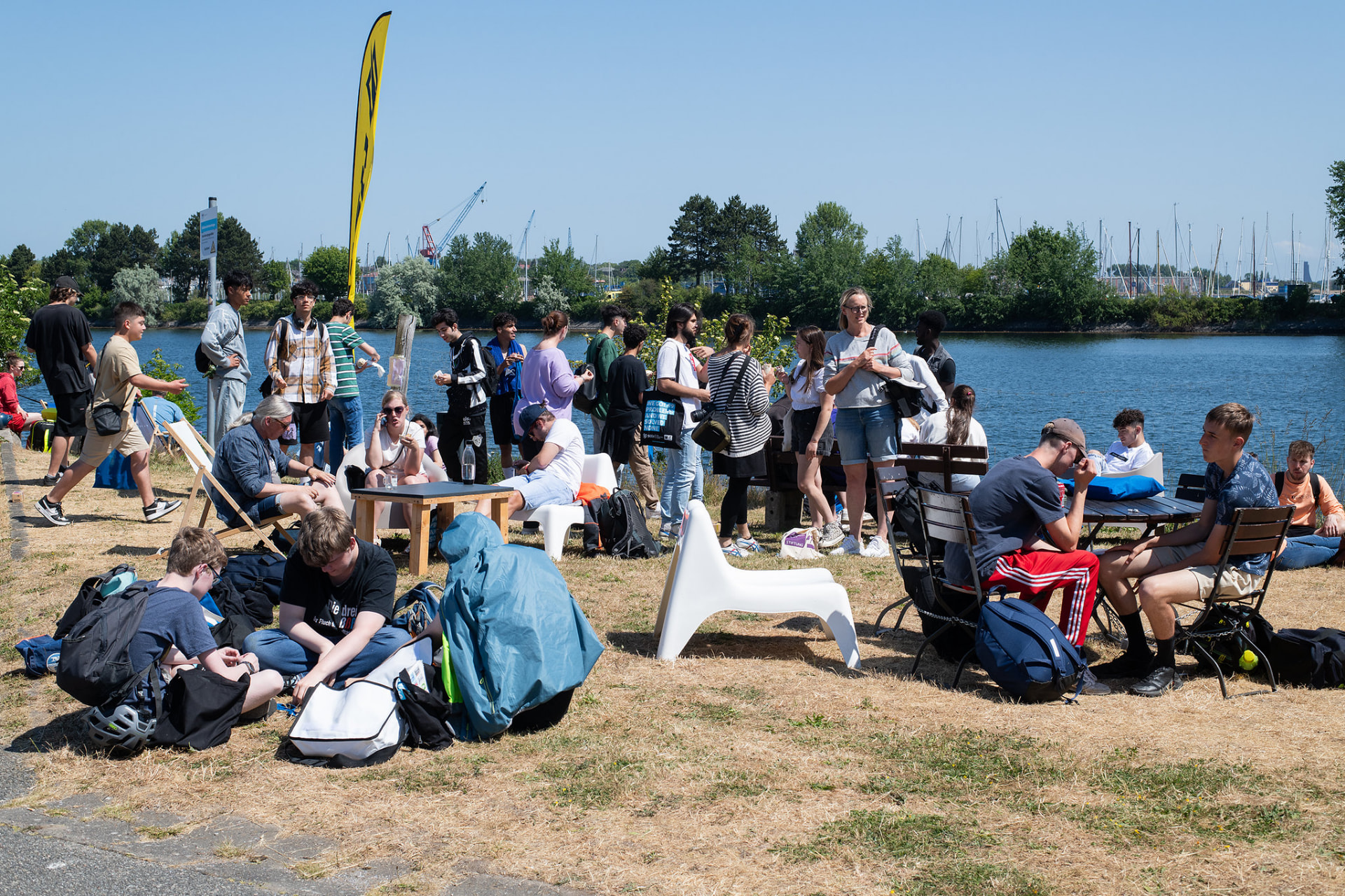 Eine vielfältige Gruppe von Menschen begegnet sich am Wasser